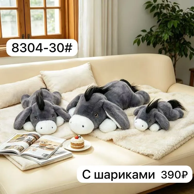 Мягкая игрушка в виде лежачего ослика с шариком — забавный